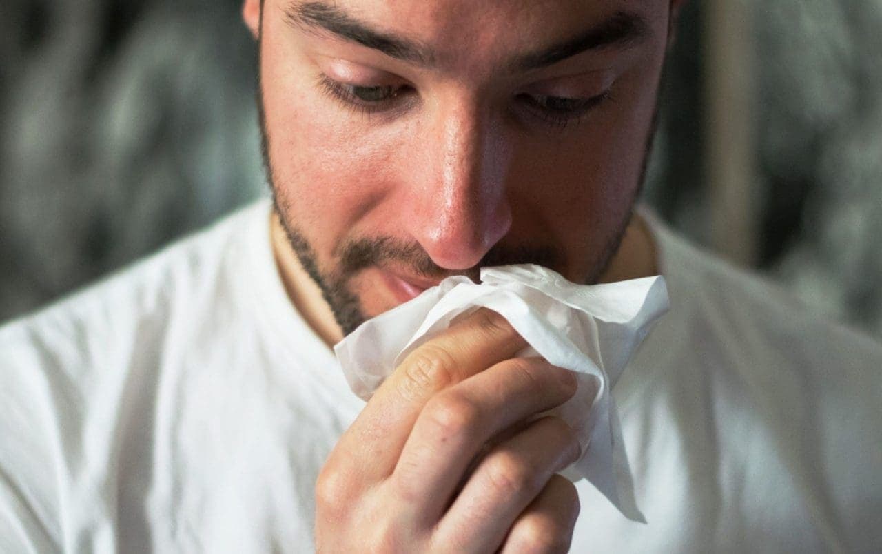 a man wiping his nose